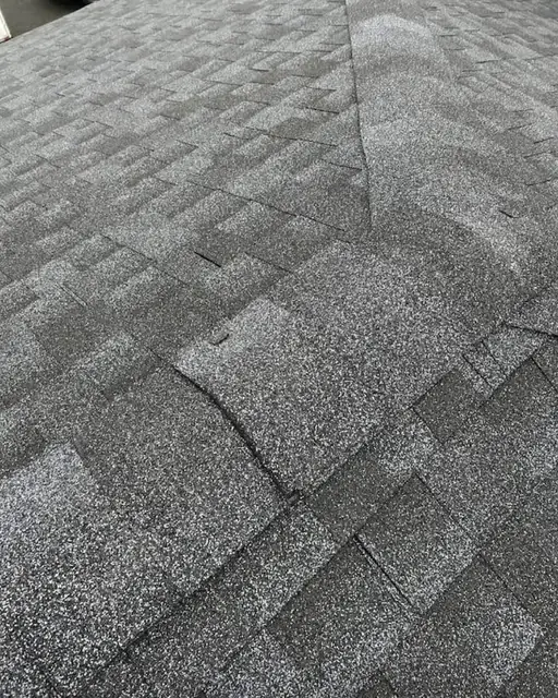 Close-up of gray architectural asphalt shingles along a roof ridge