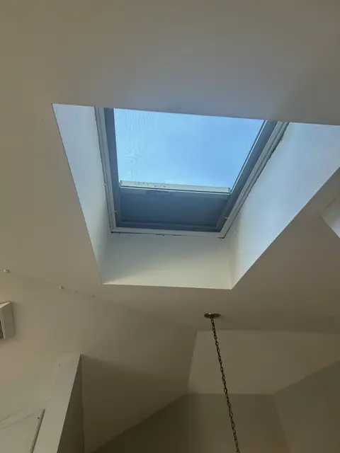 Ceiling skylight shaft viewed from below in a bright hallway